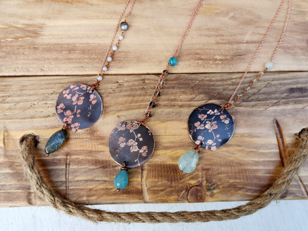 collana lunga in rame con ciondolo orchidea inciso e pietre dure