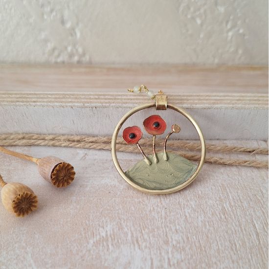 collana con ciondolo con papavero e prato verde